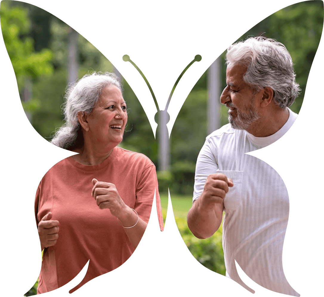 A senior couple walking together in the gardens, framed inside a butterfly-shaped mask
